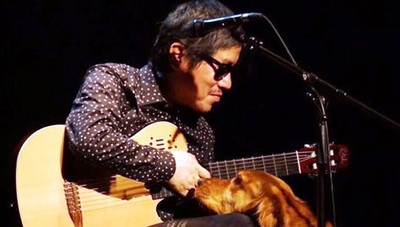 Yunpeng, junto a su perro guía, sobre el escenario durante una actuación