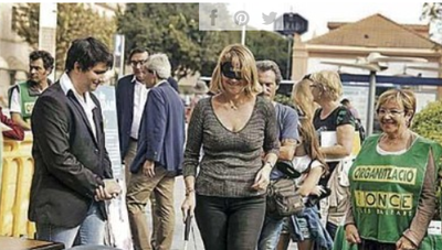 Una mujer, provista de un antifaz opaco y un bastón blanco, intenta sortear el circuito de movilidad en Palma
