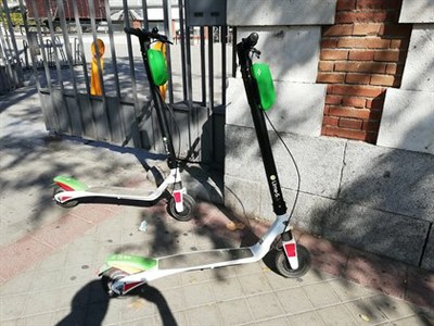 Dos patinetes aparcados en una acera