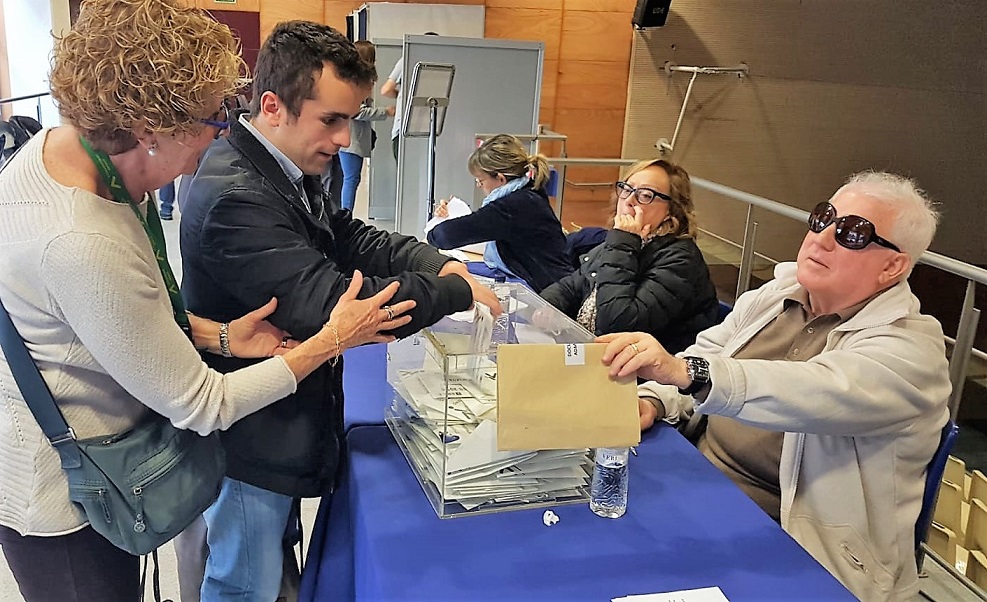 Un joven afiliado, asistido por una acompañante, vota en la Territorial catalana