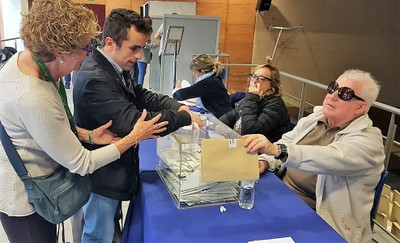 Un joven afiliado, asistido por una acompañante, vota en la Territorial catalana