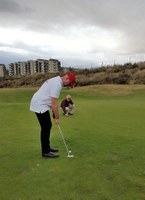 El golfista afiliado, intentando embocar una bola en el hoyo
