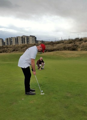 El golfista afiliado, intentando embocar una bola en el hoyo