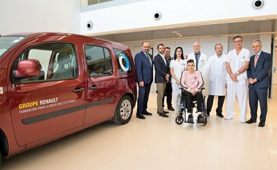 Responsables del hospital y de ILUNION posan, junto a un paciente, con el nuevo vehículo