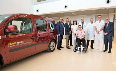 Responsables del hospital y de ILUNION posan, junto a un paciente, con el nuevo vehículo