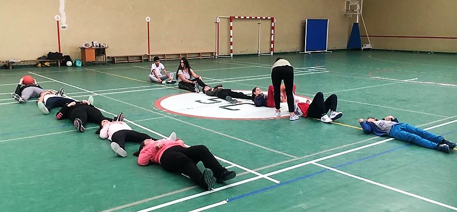 Los alumnos hacen ejercicios sobre el suelo en el gimnasio