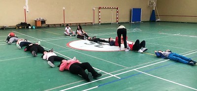 Los alumnos hacen ejercicios sobre el suelo en el gimnasio