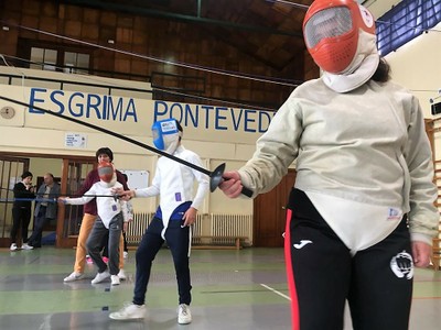 Tres alumnos se preparan para comenzar la práctica de esgrima