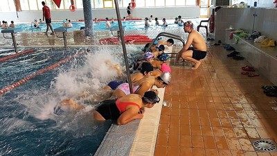 Un grupo de afiliados hace prácticas de Natación dirigido por un monitor