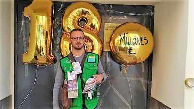 El vendedor, con un montaje de globos festejando el reparto de los 18 millones
