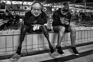 Segundo premio, dos jóvenes nadadoras (una de ellas con prótesis en ambas piernas) sentadas a la orilla de la piscina