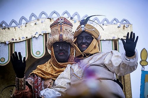 El rey Baltasar (encarnado por Cristóbal Martínez), a la izquierda, saluda en compañía de su paje durante la cabalgata de Sevilla
