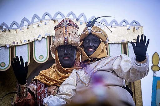El rey Baltasar (encarnado por Cristóbal Martínez), a la izquierda, saluda en compañía de su paje durante la cabalgata de Sevilla