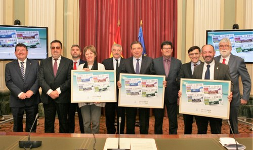 Foto de familia con los asistentes al acto mostrando la colección de cupones dedicados