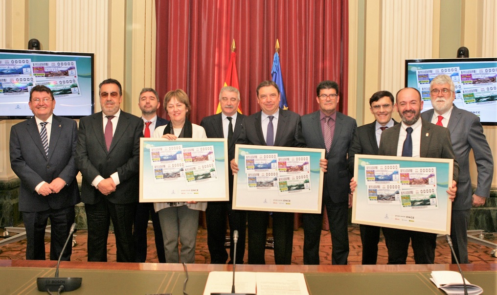 Foto de familia con los asistentes al acto mostrando la colección de cupones dedicados
