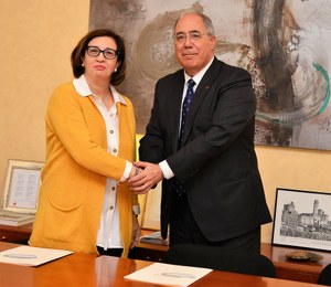 Isabel Martínez estrecha la mano del rector Roberto Fernández, tras rubricar el convenio