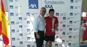 Jacobo Garrido recoge la copa que le acredita como mejor nadador juvenil masculino de manos del presidente de la Fundación AXA