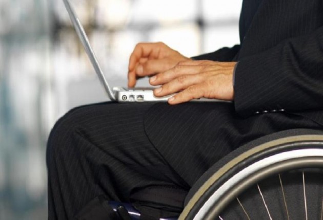 Primer plano de un hombre en silla de ruedas utilizando un ordenador portátil