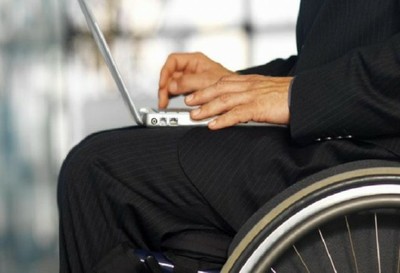 Primer plano de un hombre en silla de ruedas utilizando un ordenador portátil