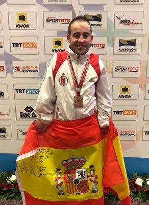 Alex Vidal con el bronce, muestra la bandera española