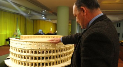 Un visitante observa y toca la maqueta del Coliseo romano