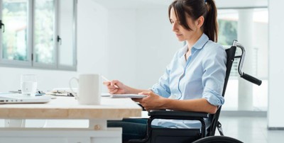Mujer joven en silla de ruedas, trabajando