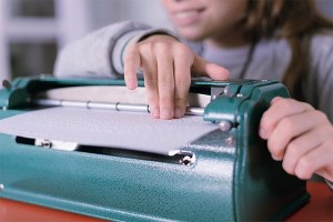 Niña ciega manejando una máquina Perkins