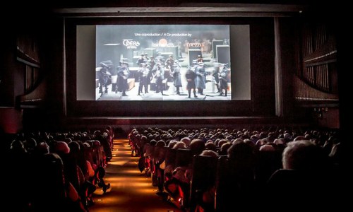 Proyección en una sala de cine con el patio de butacas lleno 