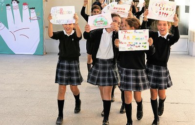 Un grupo de niñas muestra, con gesto festivo, sus dibujos inspirados en el argumento del Concurso