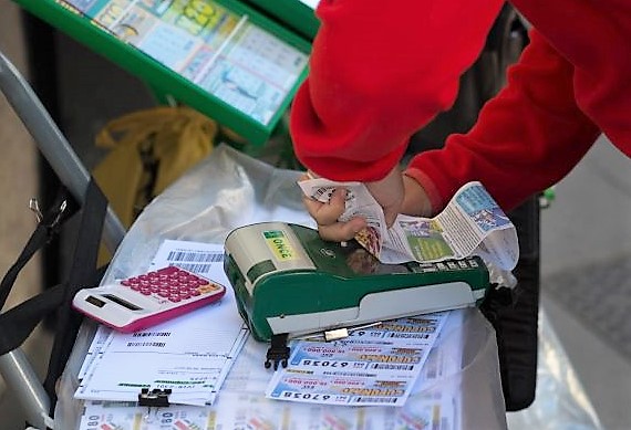Un vendedor de la ONCE corta del TPV el papel de un resguardo de juego