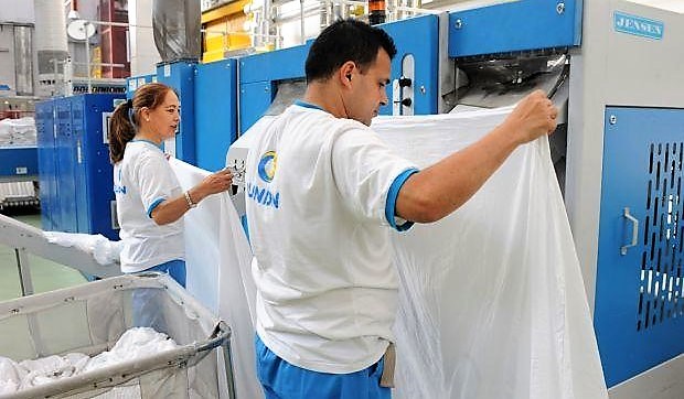 Dos trabajadores de Ilunion lavanderías en uno de sus centros indistriales