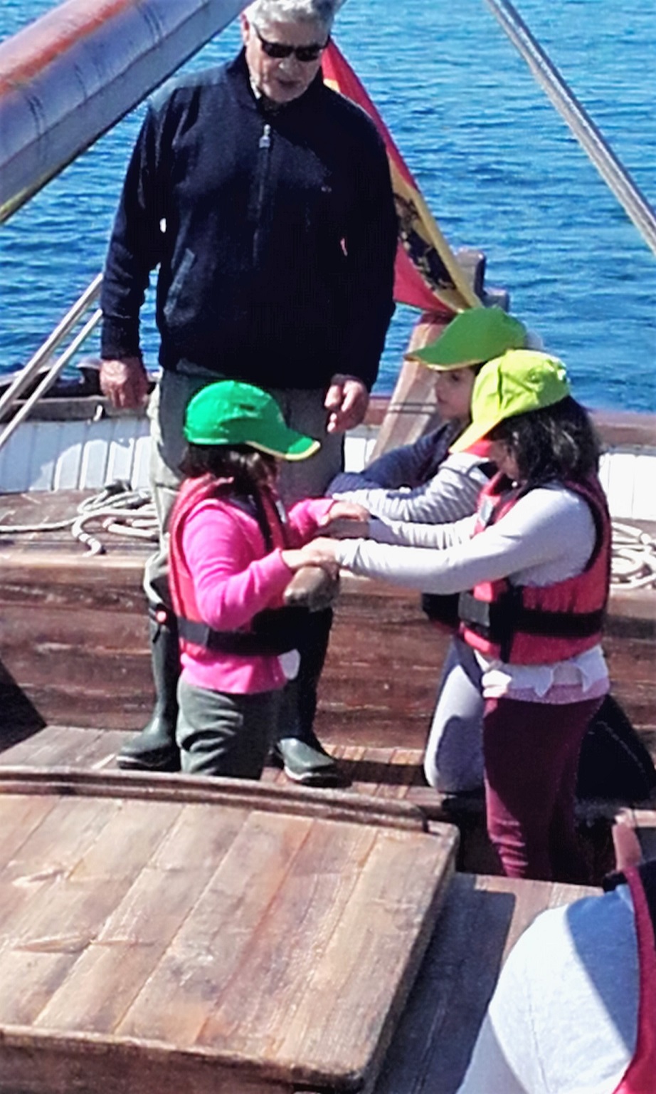 Bajo las indicaciones de un instructor de a bordo, tres pequeñas aprenden a mover el timón de la nave