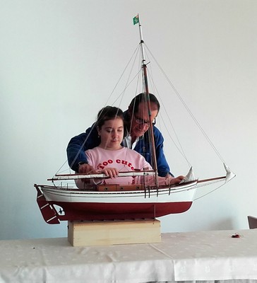 Una de las niñas conoce al tacto las características del galeón sobre una maqueta del mismo, antes de embarcar