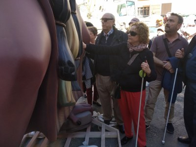 Un grupo de afiliados reconociendo al tacto un monumento fallero