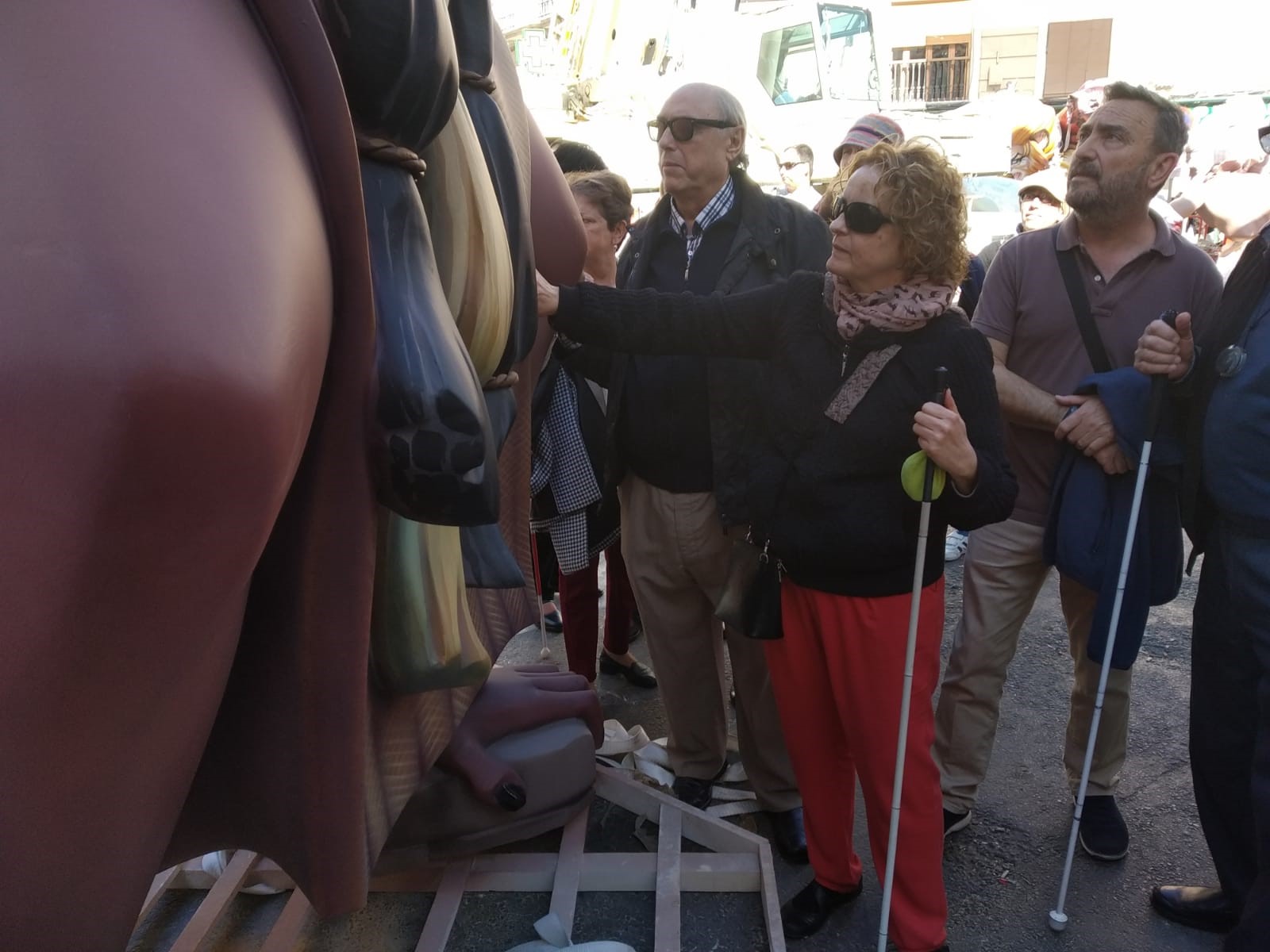 Un grupo de afiliados reconociendo al tacto un monumento fallero