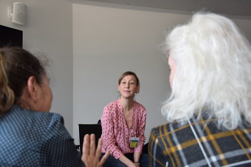 Ana Colom, de Ilunion Sociosanitario, escuchas a dos de las participantes en el taller dirigido a personas cuidadoras