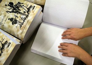 Una persona ciega lee un pasaje de El Quijote en braille