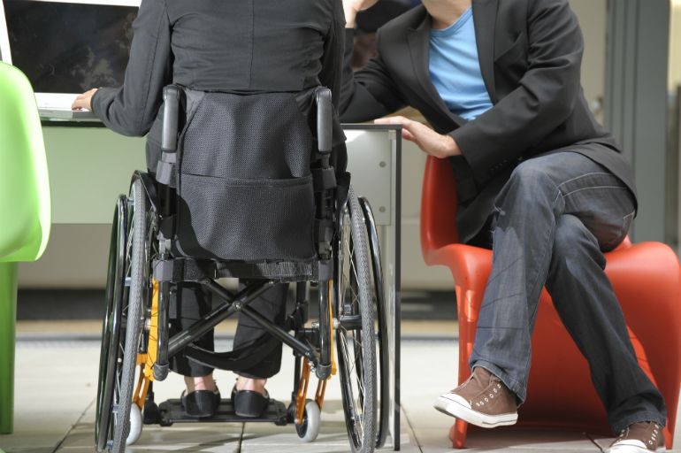 Persona en silla de ruedas en su puesto de trabajo
