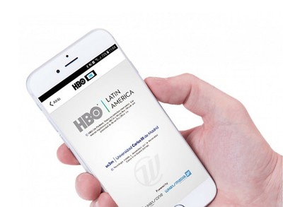 Una mano sostiene un teléfono móvil cuya pantalla muestra la aplicación de HBO IN