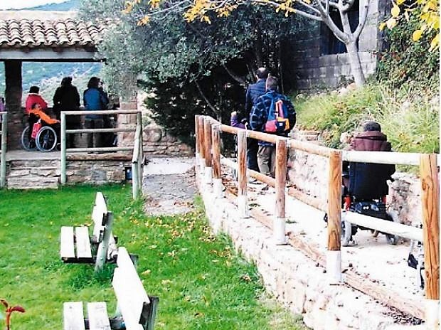 Visitantes a un Parque Natural, algunos de ellos con discapacidad (en silla de ruedas) se acercan a un mirador de montaña