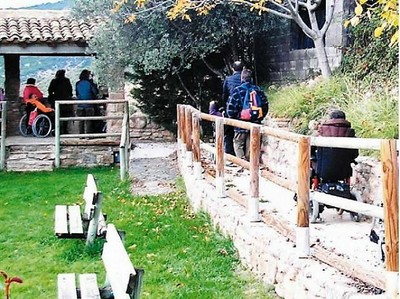 Visitantes a un Parque Natural, algunos de ellos con discapacidad (en silla de ruedas) se acercan a un mirador de montaña