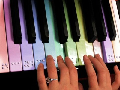 Manos tocando un teclado de piano en braille