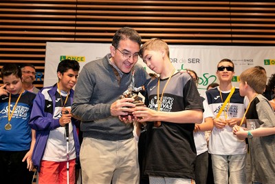 El director general adjunto de Servicios Sociales de la ONCE, Andrés Ramos, entrega uno de los trofeos a un estudiante afiliado en la clausura