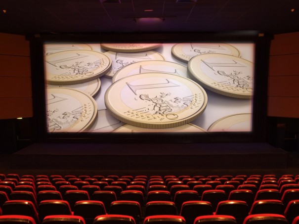 Sala de cine con imagen de monedas en la pantalla