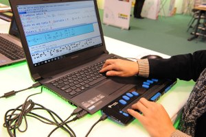 Un técnico maneja un ordenador conectado a línea braille