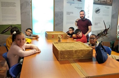 Uno de los profesores con los más pequeños dispuestos a buscar fósiles en el arenero