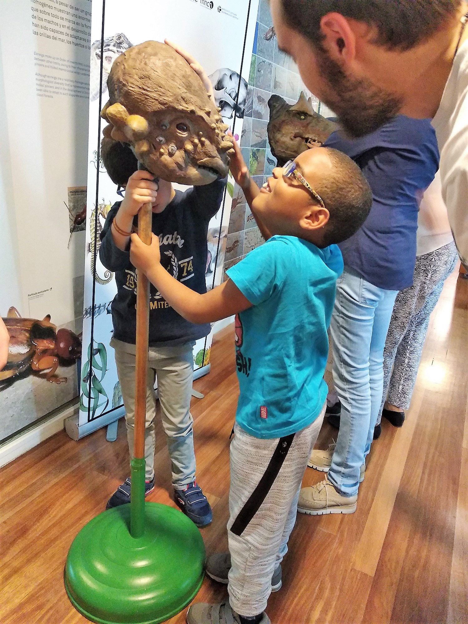 Dos pequeños afiliados tocan la cabeza de un Pachycephalosaurus