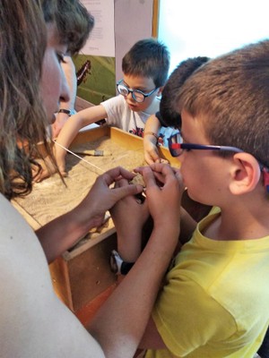 Niños afiliados recrean la experiencia de una excavación de huesos de dinosaurios