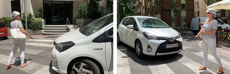 Mujer ciega con bastón cruzando un paso de cebra junto a un vehículo híbrido