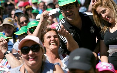 Varios asistentes festejan, en el Parque de Atracciones, un premio del sorteo de regalos celebrado en Madrid